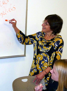 Nancy Steinberg Warren writing on a whiteboard.